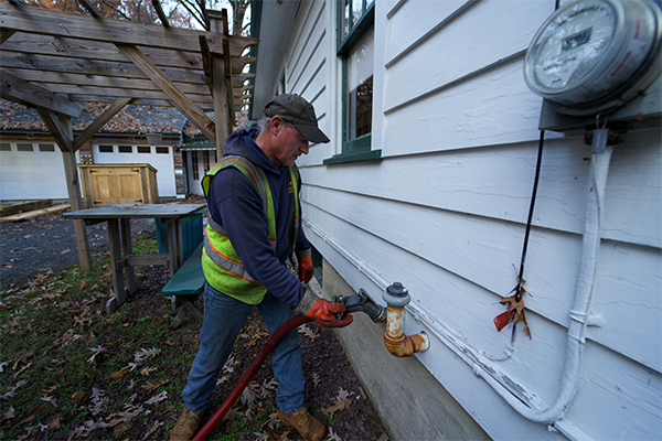 Sunday heating oil delivery driver filling a residential oil tank on Long Island